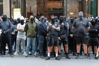 ROYAUME-UNI : MASQUÉS ET HABILLÉS DE NOIR, DES MILITANTS D’EXTRÊME DROITE BRITANNIQUES TRAQUENT LES MIGRANTS